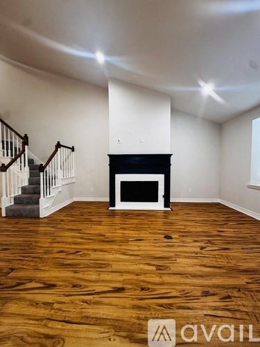 A room with a fireplace and wooden floors.