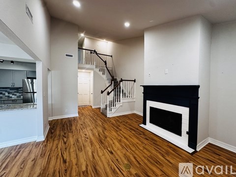 A living room with a fireplace and a staircase.