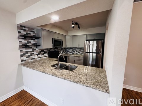 A kitchen with granite countertops and stainless steel appliances.