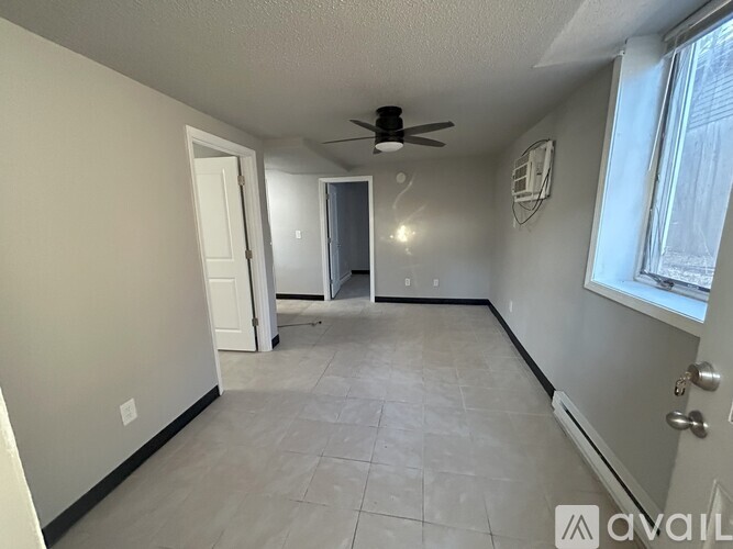 A room with a ceiling fan and tile flooring.