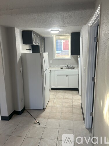 A kitchen with white appliances and cabinets.