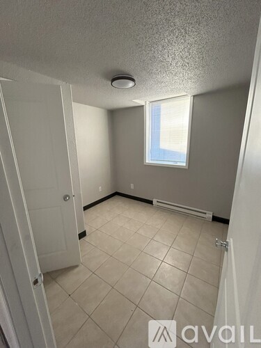 A room with a door, a window, and a tiled floor.