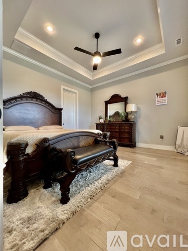 A bedroom with a large bed and a bench.