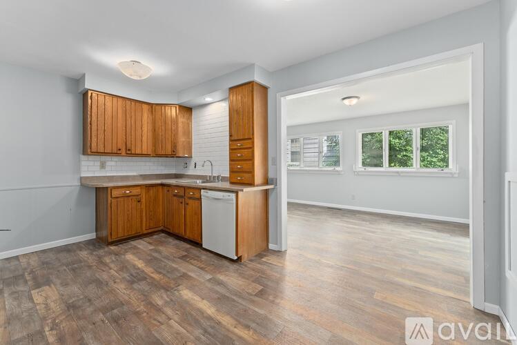 A kitchen with wooden cabinets and a white dishwasher.