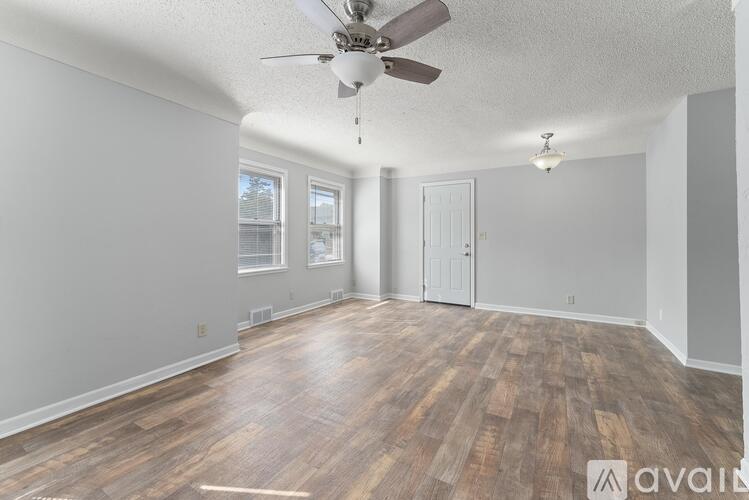 A room with wooden flooring and a ceiling fan.