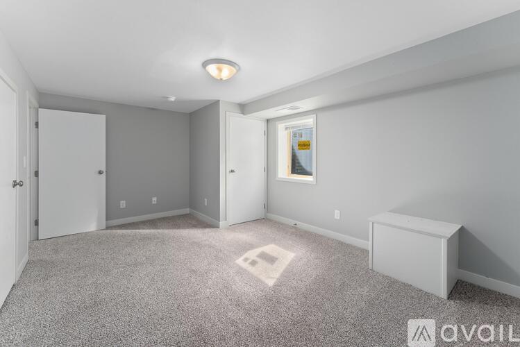 A spacious room with a carpeted floor and a window.