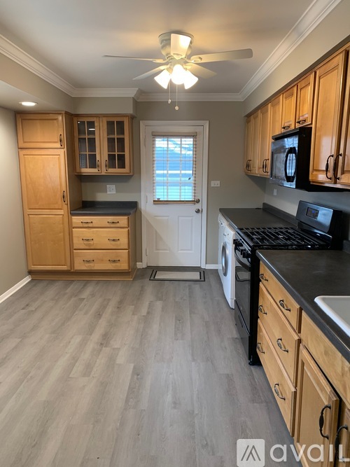 A kitchen with wooden cabinets and a black countertop.