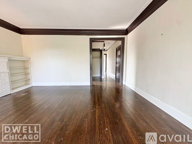 A hallway with wooden floors and white walls.