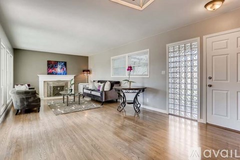 A living room with a grey couch, a coffee table, and a painting on the wall.