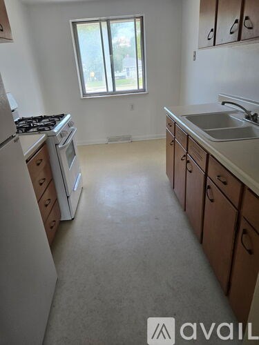 A kitchen with white appliances and wooden cabinets.