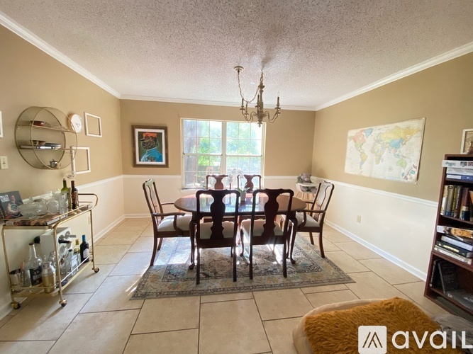 A dining room with a table set for six and a chandelier hanging from the ceiling.