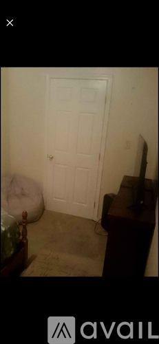 A white door is in a room with a brown table and a white bean bag chair.