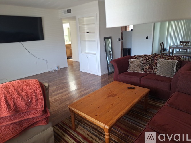 A living room with a red couch and a wooden coffee table.