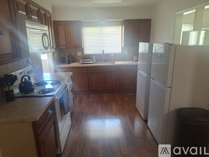 A kitchen with wooden cabinets and a white fridge.