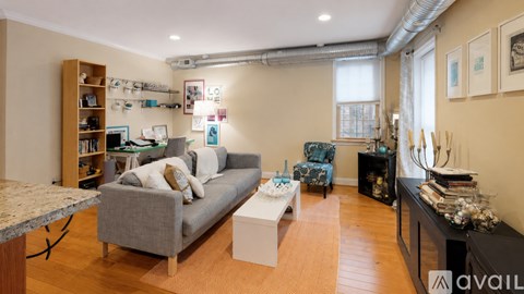 A living room with a grey couch and a white coffee table.