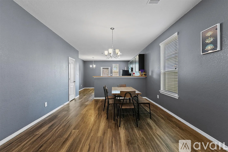 A dining room with a wooden table and chairs.