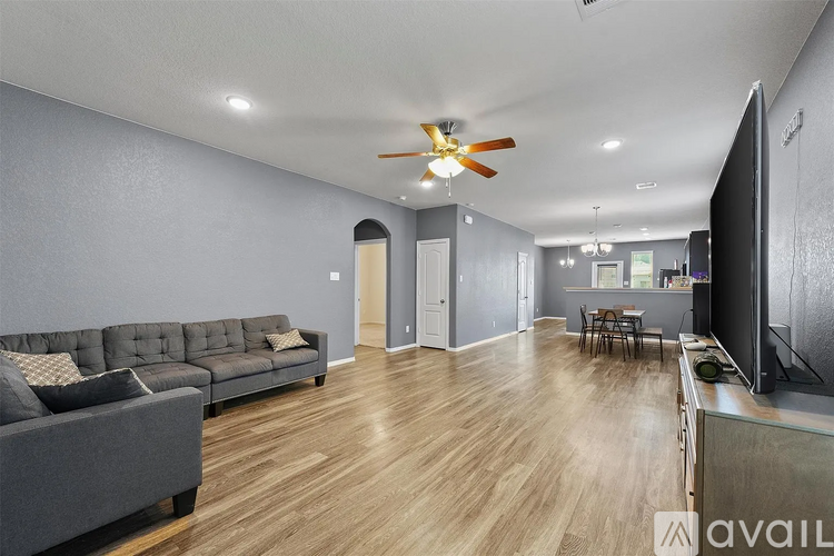 A living room with a grey couch and a wooden floor.