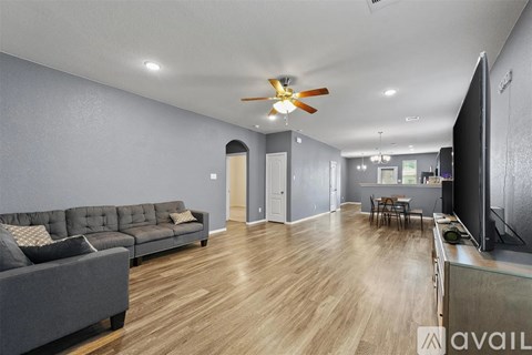 A living room with a grey couch and a wooden floor.