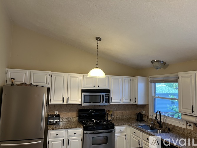 A kitchen with white cabinets and a refrigerator.