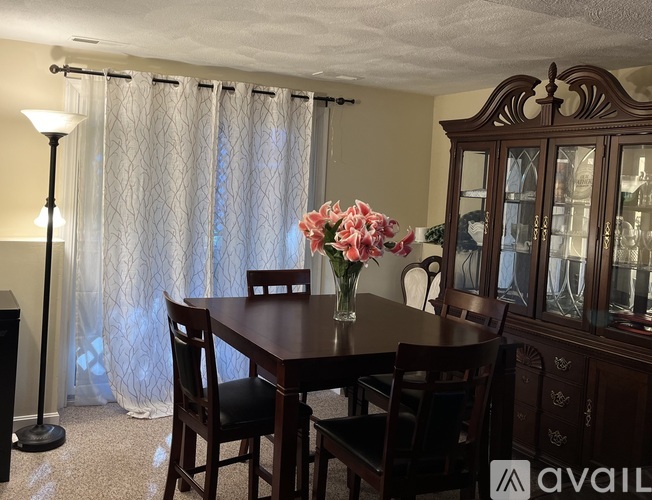 A dining room with a wooden table and chairs.