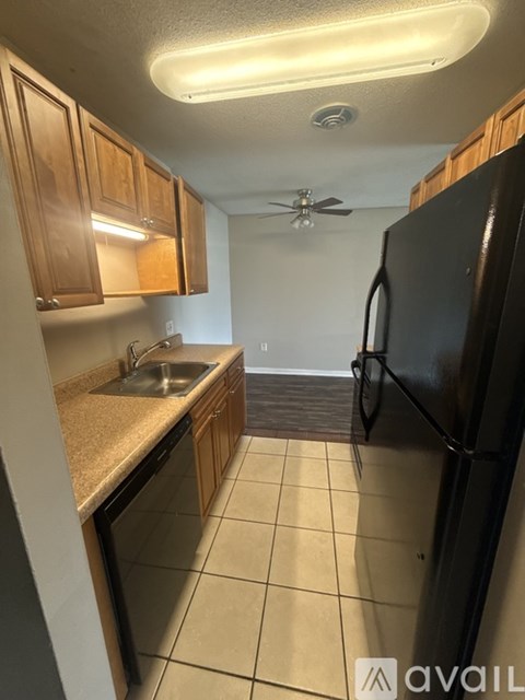 A kitchen with black appliances and wooden cabinets.