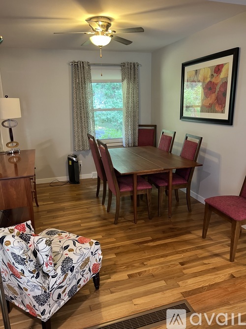 A dining room with a wooden table and chairs.