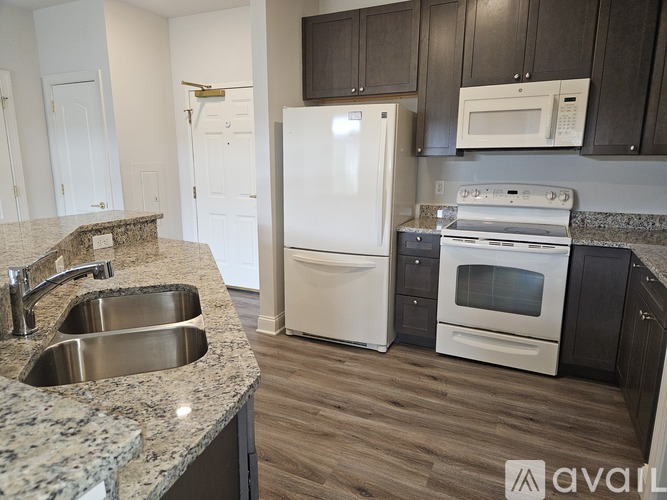 A kitchen with a white refrigerator, stove, and microwave.