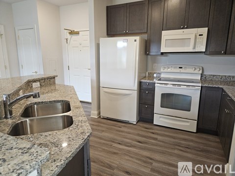 A kitchen with a white refrigerator, stove, and microwave.