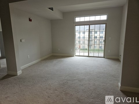 A room with a carpeted floor and a large window.