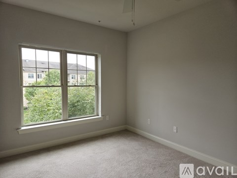 A room with a large window and carpeted floor.