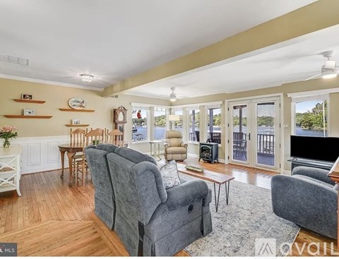 A living room with a grey couch and a wooden floor.