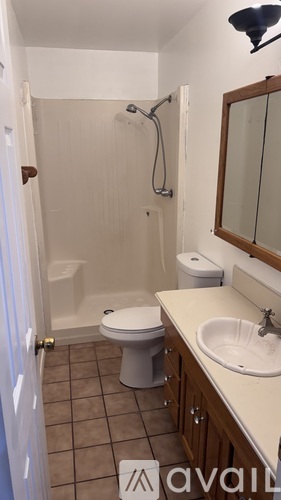 A bathroom with a toilet, sink, and shower.