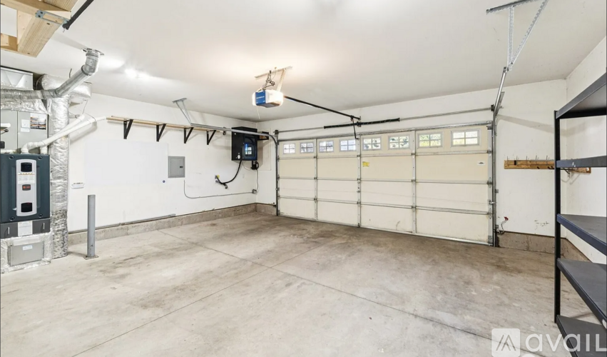 A spacious garage with a white ceiling and a large white door.
