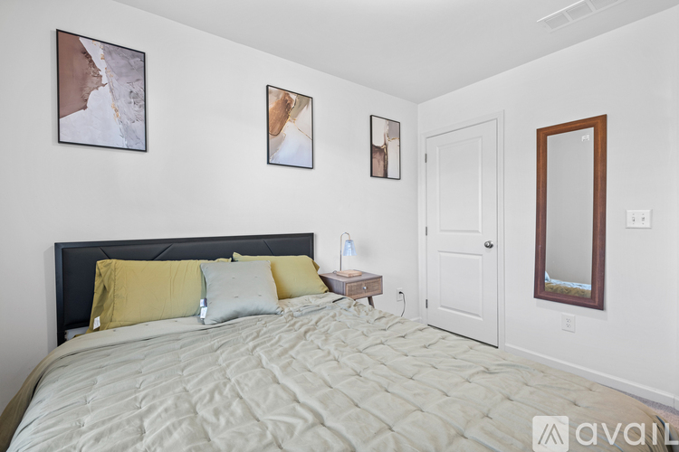 A bedroom with a large bed and two pictures on the wall.