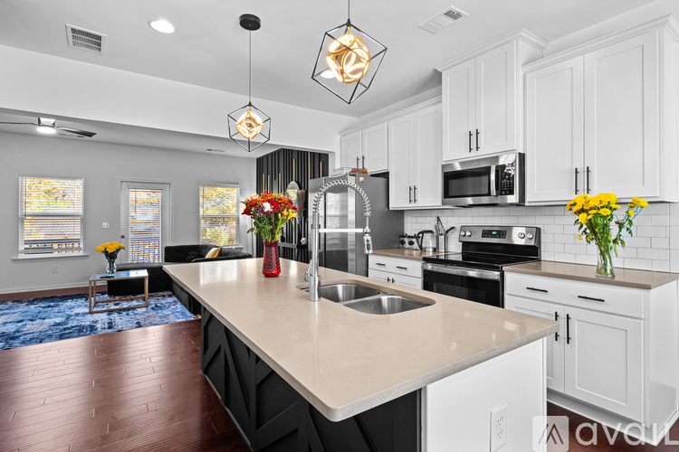 A kitchen with white cabinets and a wooden island.