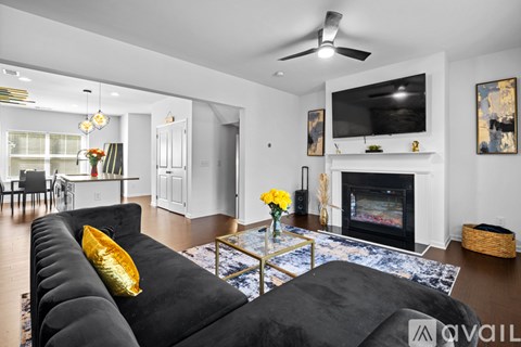 A living room with a black couch and a fireplace.