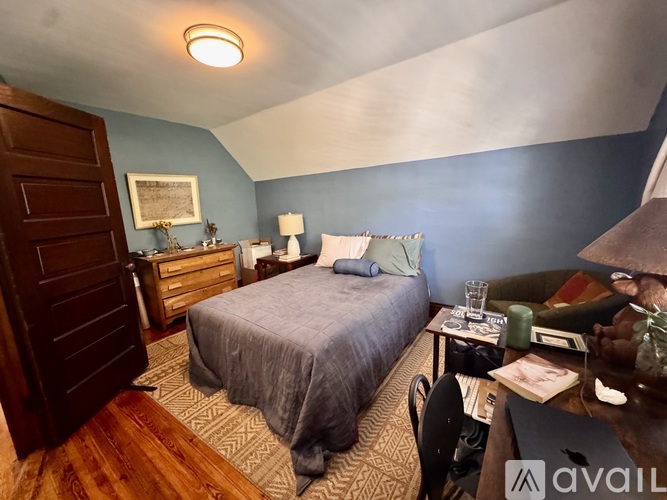 A bedroom with a bed, desk, and chair.