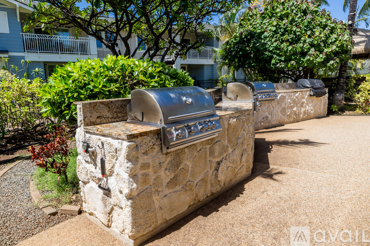 A stone mailbox sits on a sidewalk in front of a building.