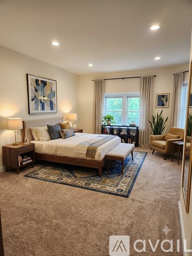 A bedroom with a large bed and a rug on the floor.