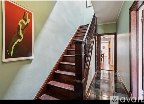 A staircase with a green wall and a red picture on the wall.