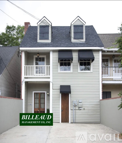 A two-story house with a sign that says "BILLEAUD MANAGEMENT CO., INC." in front of it.