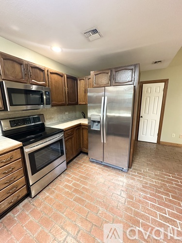 A kitchen with a stove, oven, refrigerator, and microwave.