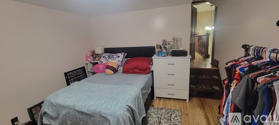 A bedroom with a bed, dresser, and closet.