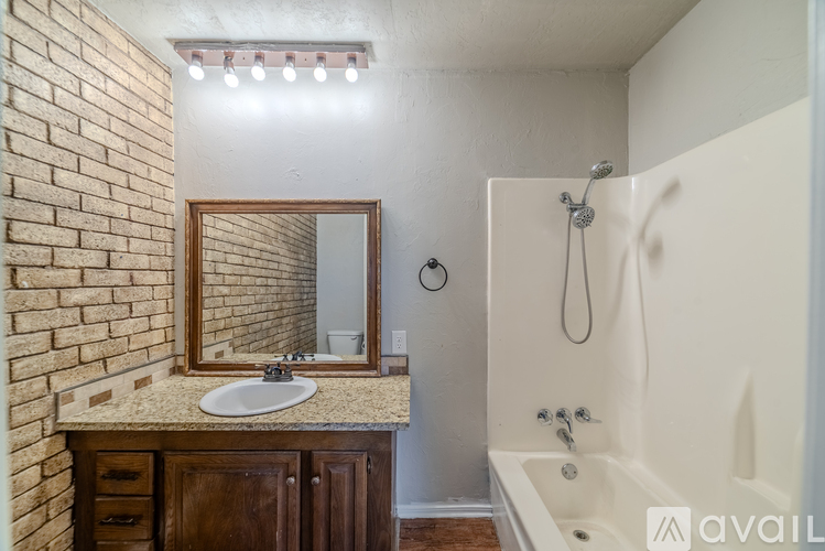 A bathroom with a sink, mirror, and bathtub.