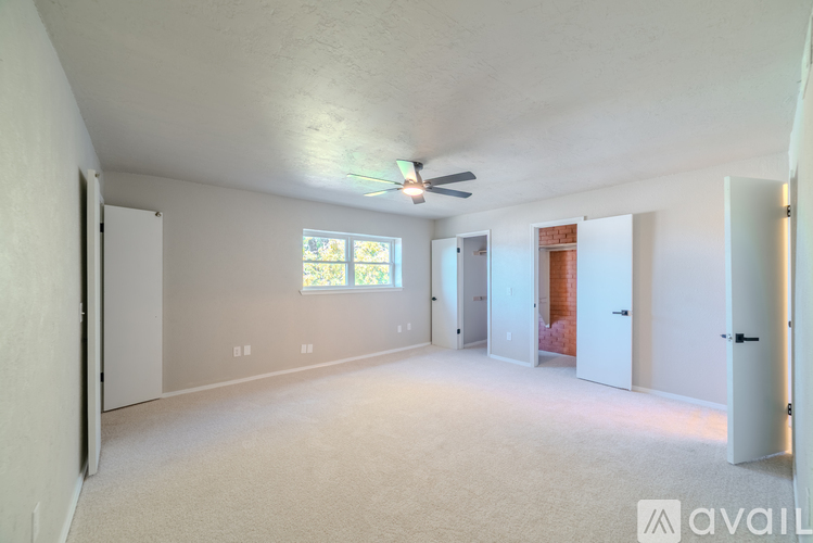 A spacious room with a ceiling fan and a window.
