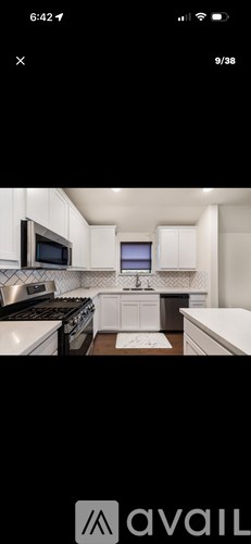 A modern kitchen with white cabinets and stainless steel appliances.