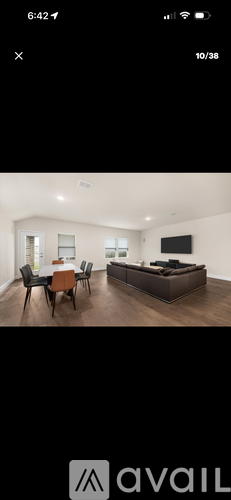 A modern living room with a brown sofa and a wooden dining table.