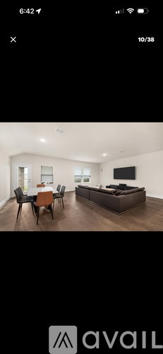 A modern living room with a brown sofa and a wooden dining table.