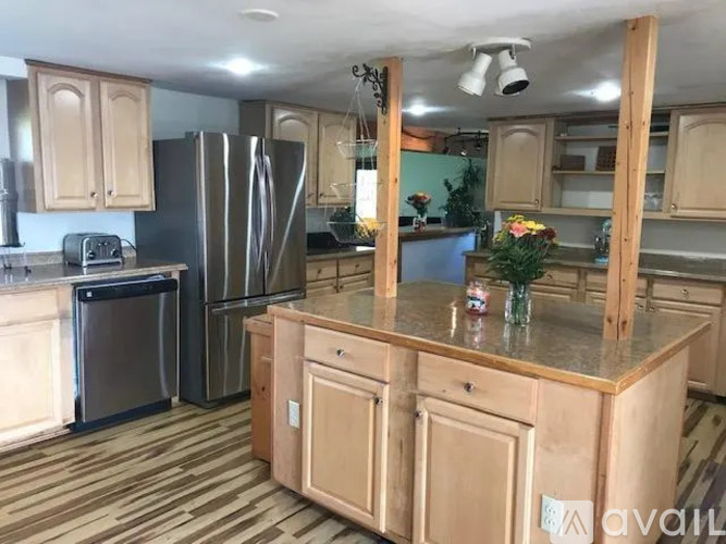 A kitchen with wooden cabinets and a granite countertop.