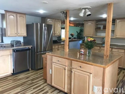 A kitchen with wooden cabinets and a granite countertop.